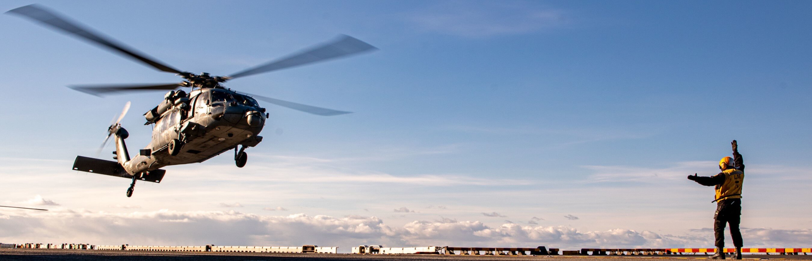 Ground crewmember directs helicopter during landing